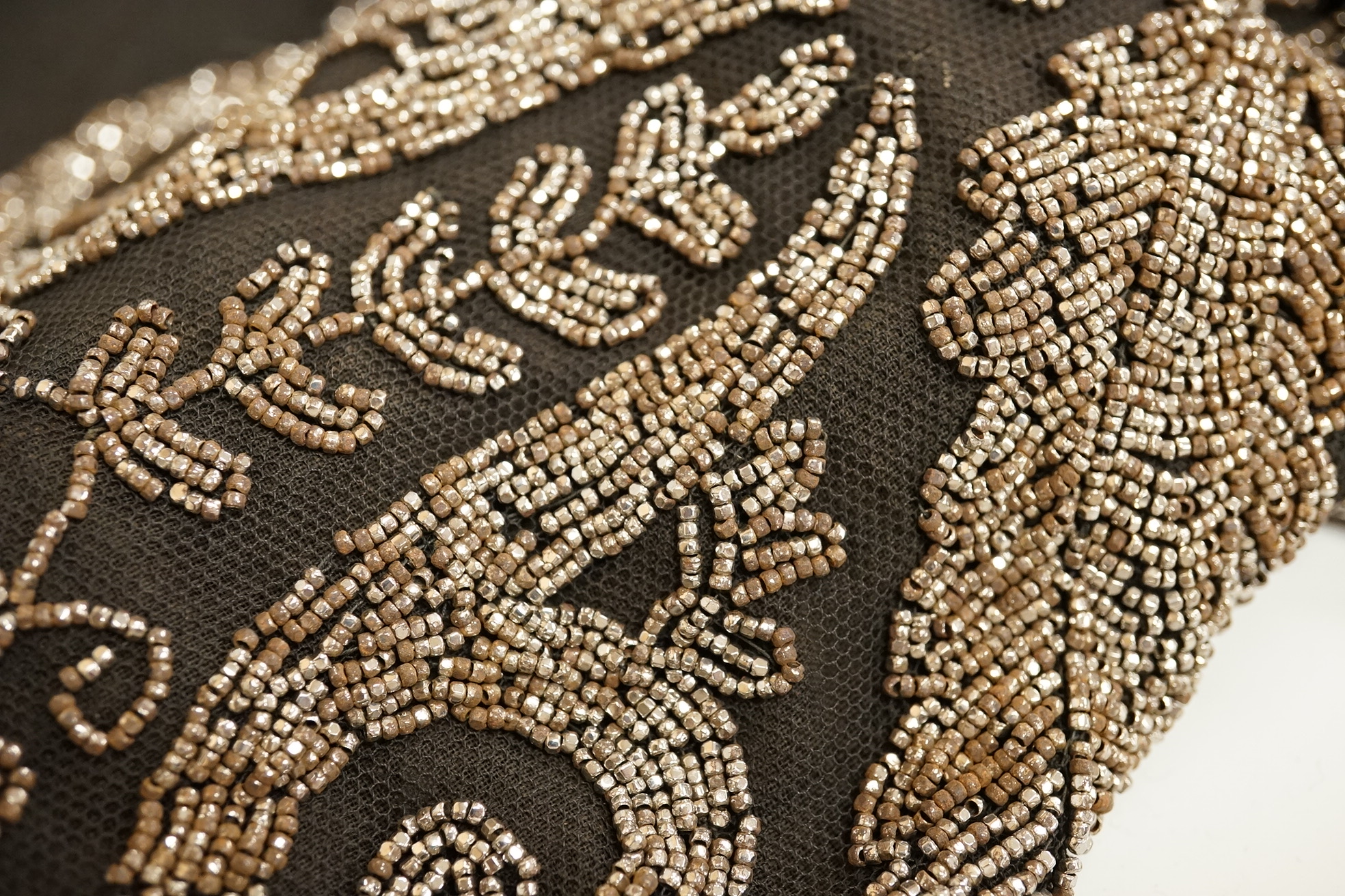 A cut steel fronter, a jet beaded panel, a pair of fringed black suede gauntlets, a seed pearl headdress, etc.